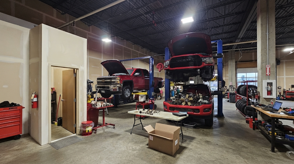 GDL Auto shop interior with trucks on lifts and engine parts on the workbench